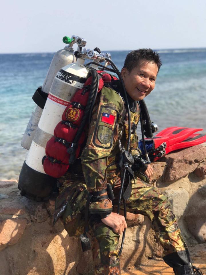 John Fang sitting next to a dive site wearing a Prism 2 rebreather